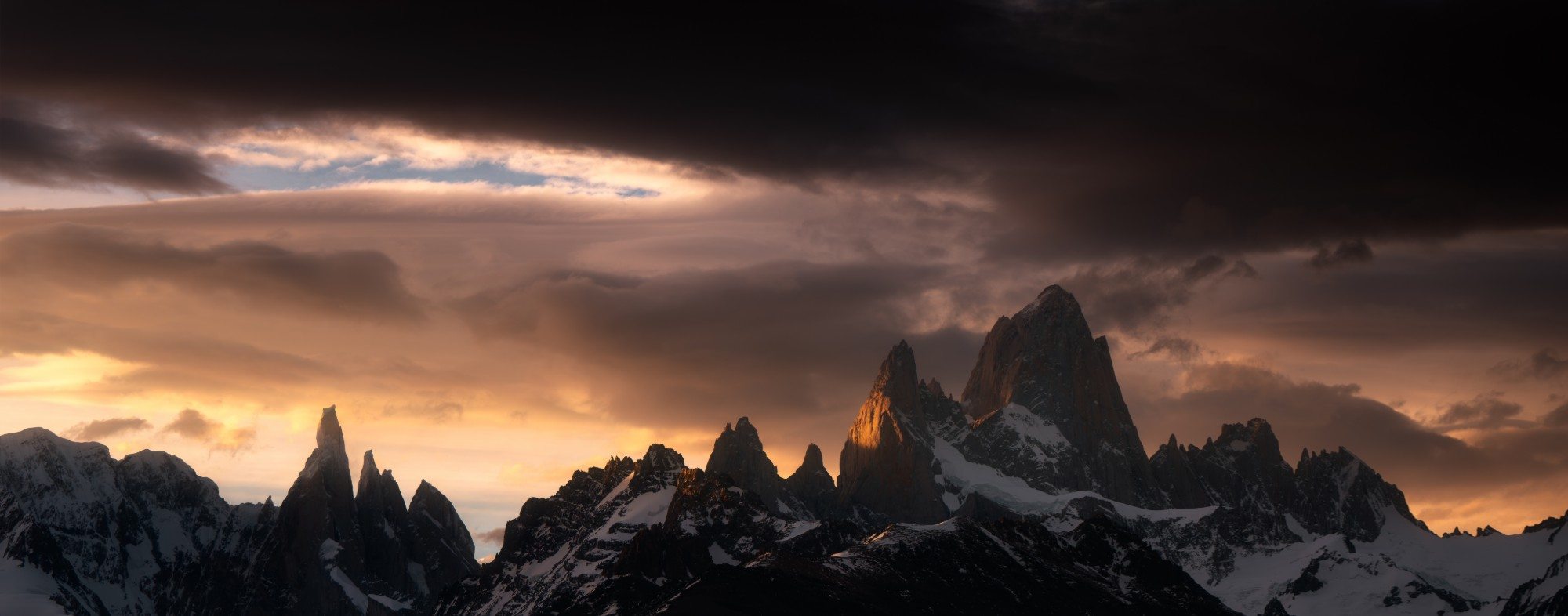 Fitz Roy and its needles at last light under a dark sky, Patagonia